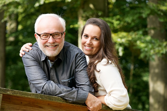 Happy older Man Smiling With Young Woman